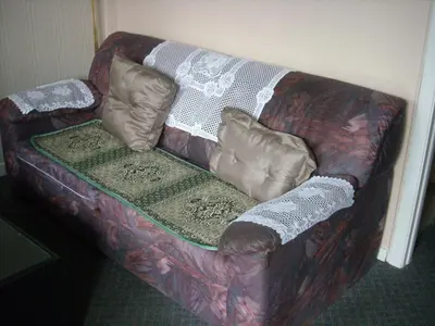 a couch with pillows on it in a room at Motel le Verseau in Sorel