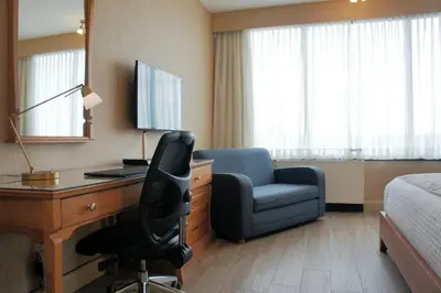 a hotel room with a desk and a chair and a bed at Hôtel Castel in Granby