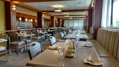 a dining room with long tables and chairs at Hôtel Castel in Granby