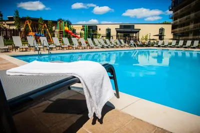 a towel on a bench next to a swimming pool at Hôtel Castel in Granby