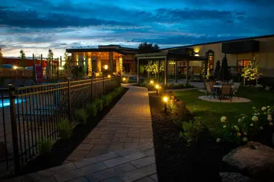 a backyard with a fence and a patio with lights at Hôtel Castel in Granby