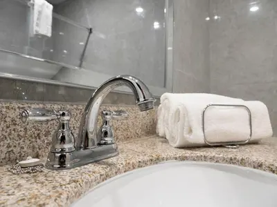 a bathroom sink with a faucet and a towel at Motel Classique in Joliette