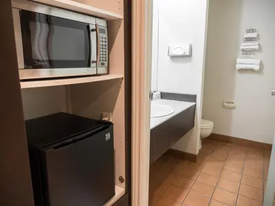 a small bathroom with a microwave and a sink at Motel Classique in Joliette