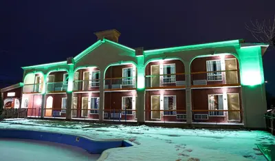 a large building with green lights on it at night at Motel Classique in Joliette