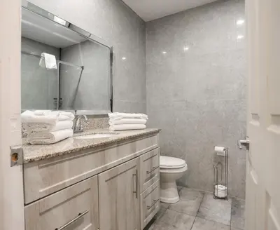 a bathroom with a sink and a toilet and a mirror at Motel Classique in Joliette