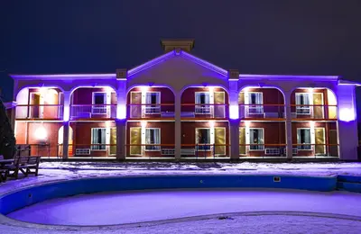 a large building with purple lights in the snow at Motel Classique in Joliette