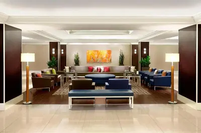a lobby with couches and tables and a painting at Sheraton Montreal Airport Hotel in Dorval