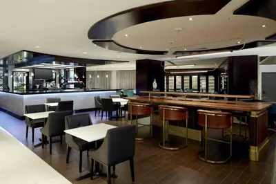 a restaurant with a bar and tables and chairs at Sheraton Montreal Airport Hotel in Dorval
