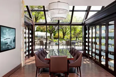 a dining room with a glass table and chairs at Sheraton Montreal Airport Hotel in Dorval