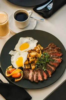 a plate of food with eggs and meat and a cup of coffee at Sheraton Montreal Airport Hotel in Dorval