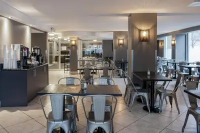 a restaurant with tables and chairs and a bar at Hotel Faubourg Montreal Centre-Ville Downtown in Montréal