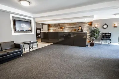 a woman standing in a lobby with a bar at Hotel Faubourg Montreal Centre-Ville Downtown in Montréal
