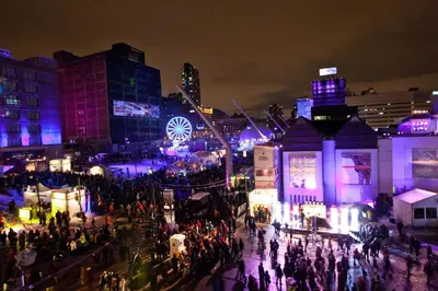 a crowd of people walking around a city at night at Hotel Faubourg Montreal Centre-Ville Downtown in Montréal