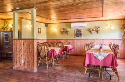 a restaurant with tables and chairs in a room at Auberge Au Soleil Levant in Piopolis