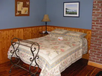 a bedroom with a bed and a lamp in it at Auberge Au Soleil Levant in Piopolis