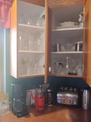 a kitchen cabinet filled with lots of glasses at 3 Bedrooms 3 beds near metro -2 Parking Free in Montréal