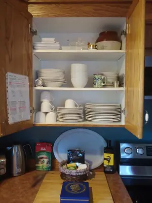 a cupboard filled with plates and dishes in a kitchen at 3 Bedrooms 3 beds near metro -2 Parking Free in Montréal