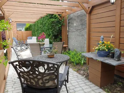 a patio with a table and chairs and a pergola at 3 Bedrooms 3 beds near metro -2 Parking Free in Montréal