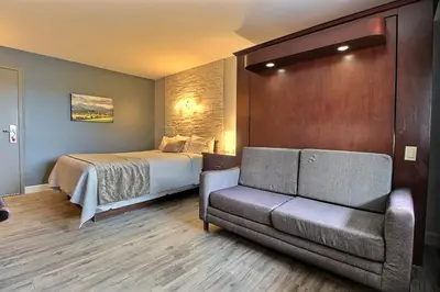 a hotel room with a bed and a couch at Hotel Motel Le Quiet in Lac-Mégantic