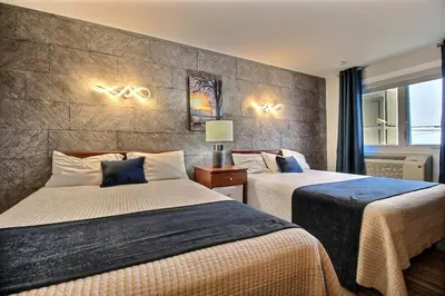 a hotel room with two beds and a window at Hotel Motel Le Quiet in Lac-Mégantic