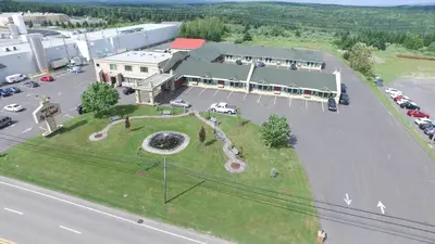an aerial view of a large building with a park at Hotel Motel Le Quiet in Lac-Mégantic