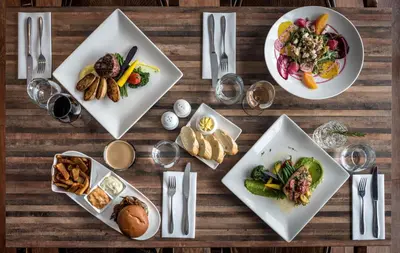 a wooden table with plates of food on it at Hotel Motel Le Quiet in Lac-Mégantic