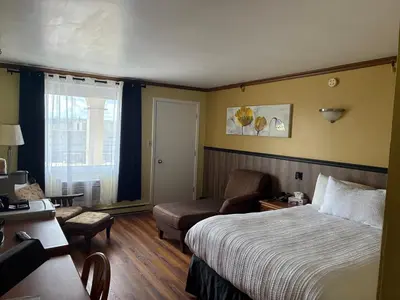 a hotel room with a bed and a couch at Hotel Motel Le Château in Lac-Mégantic
