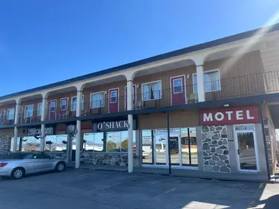 a hotel with a car parked in front of it at Hotel Motel Le Château in Lac-Mégantic