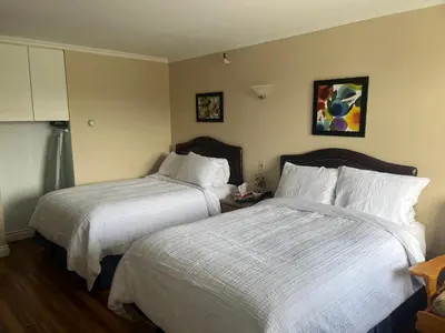 a hotel room with two beds with white sheets at Hotel Motel Le Château in Lac-Mégantic