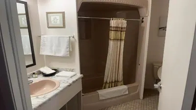 a bathroom with a sink and a shower at Hotel Motel Le Château in Lac-Mégantic