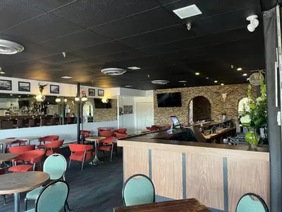 a restaurant with tables and chairs and a bar at Hotel Motel Le Château in Lac-Mégantic