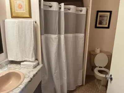 a bathroom with a shower curtain and a toilet at Hotel Motel Le Château in Lac-Mégantic