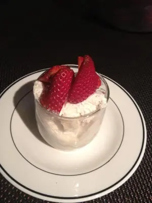 a dessert with strawberries in a bowl on a plate at Repos & Manna Downtown Montréal in Montréal