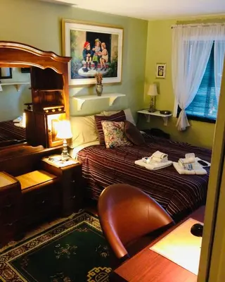 a hotel room with a bed and a chair at Repos & Manna Downtown Montréal in Montréal