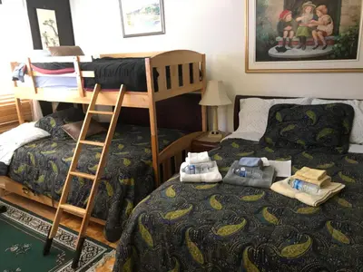 a bedroom with two beds and a bunk bed at Repos & Manna Downtown Montréal in Montréal