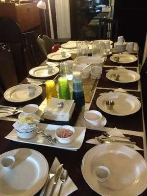 a long table with white plates and silverware on it at Repos & Manna Downtown Montréal in Montréal