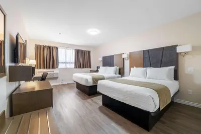 a hotel room with two beds and a desk at Hotel Montreal Metropolitan, BW Signature Collection in Montréal