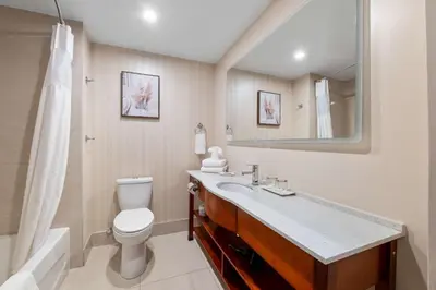 a bathroom with a toilet and a sink and a mirror at Hotel Montreal Metropolitan, BW Signature Collection in Montréal