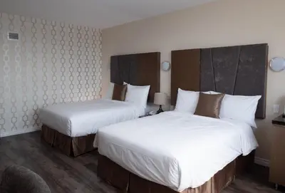 two beds in a hotel room with white sheets at Hotel Montreal Metropolitan, BW Signature Collection in Montréal