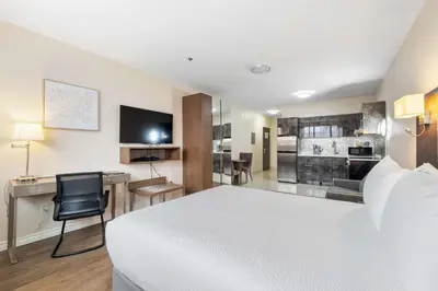 a hotel room with a white bed and a desk at Hotel Montreal Metropolitan, BW Signature Collection in Montréal