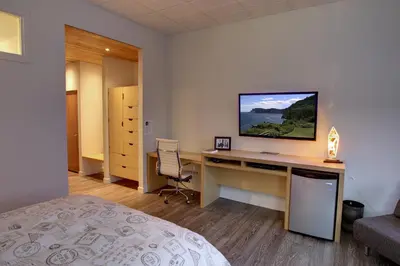 a bedroom with a desk with a television on it at Suite Marie-Thérèse in Vallée-Jonction
