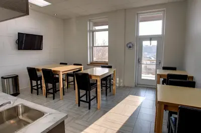 a dining room with tables and chairs and a tv at Suite Marie-Thérèse in Vallée-Jonction