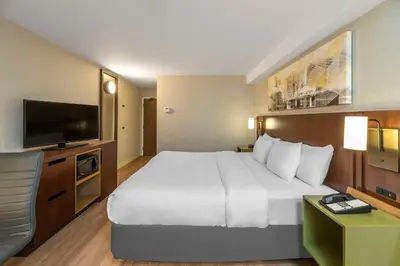 a hotel room with a large bed and a flat screen tv at Comfort Inn South in Brossard