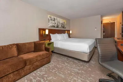 a hotel room with a bed and a couch at Comfort Inn South in Brossard