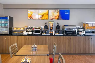 a restaurant with a counter with a table and chairs at Comfort Inn South in Brossard