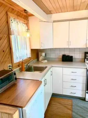 a kitchen with white cabinets and a sink at Le Rustique Orford Domaine Cheribourg in Magog-Orford