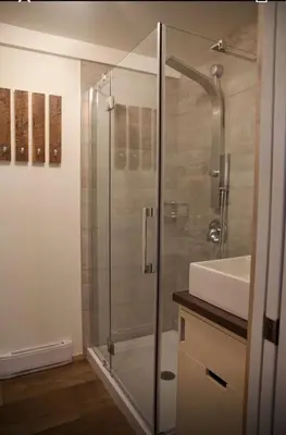a bathroom with a glass shower and a sink at Le Cocon Orford Domaine Cheribourg in Magog-Orford