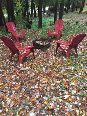 three red chairs and a fire pit in the park at Le Cocon Orford Domaine Cheribourg in Magog-Orford
