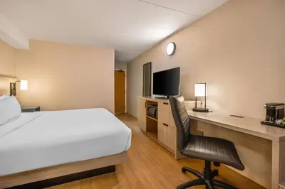a hotel room with a bed and a desk with a computer at Comfort Inn in Laval