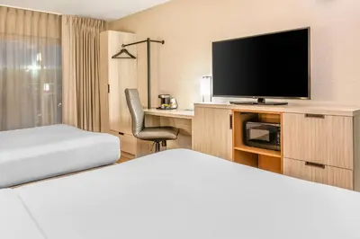 a hotel room with a bed and a flat screen tv at Comfort Inn in Laval